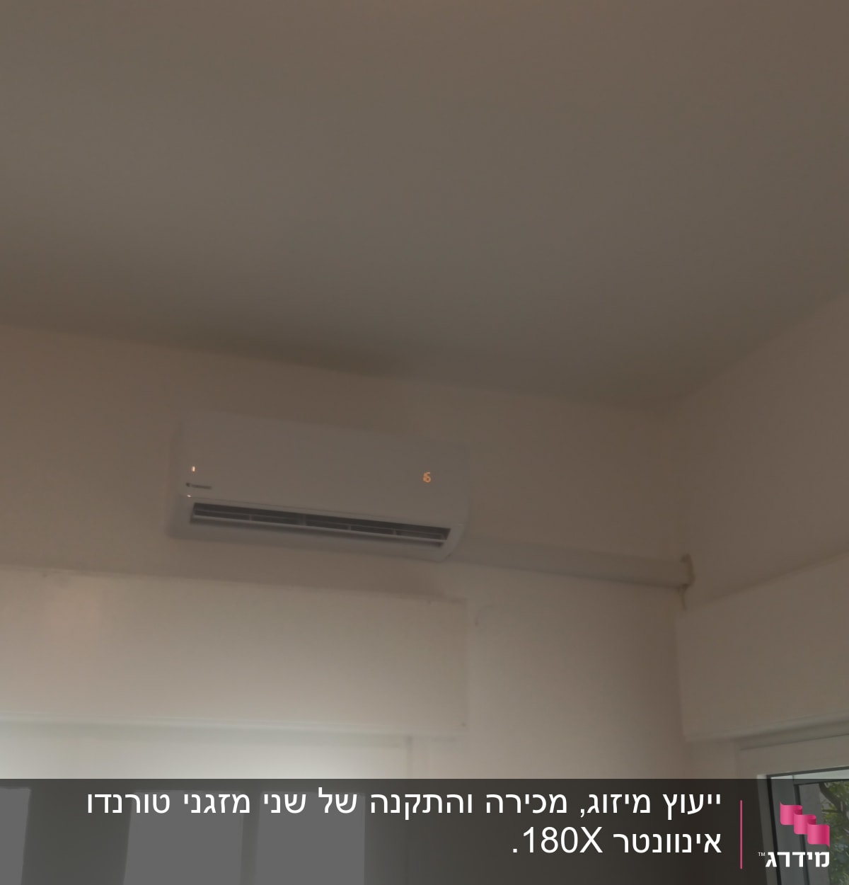 מזגן מותקן על קיר לבן עם תצוגה דולקת